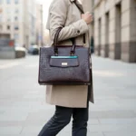 Chocolate brown crocodile-embossed genuine leather handbag with gold-tone hardware and a structured, elegant silhouette.