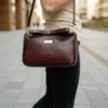Deep rich brown genuine leather handbag with crocodile-embossed texture, structured design, and gold-tone hardware