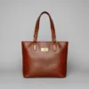 Brown genuine leather tote bag with natural grain texture, featuring a spacious design for elegant everyday use.